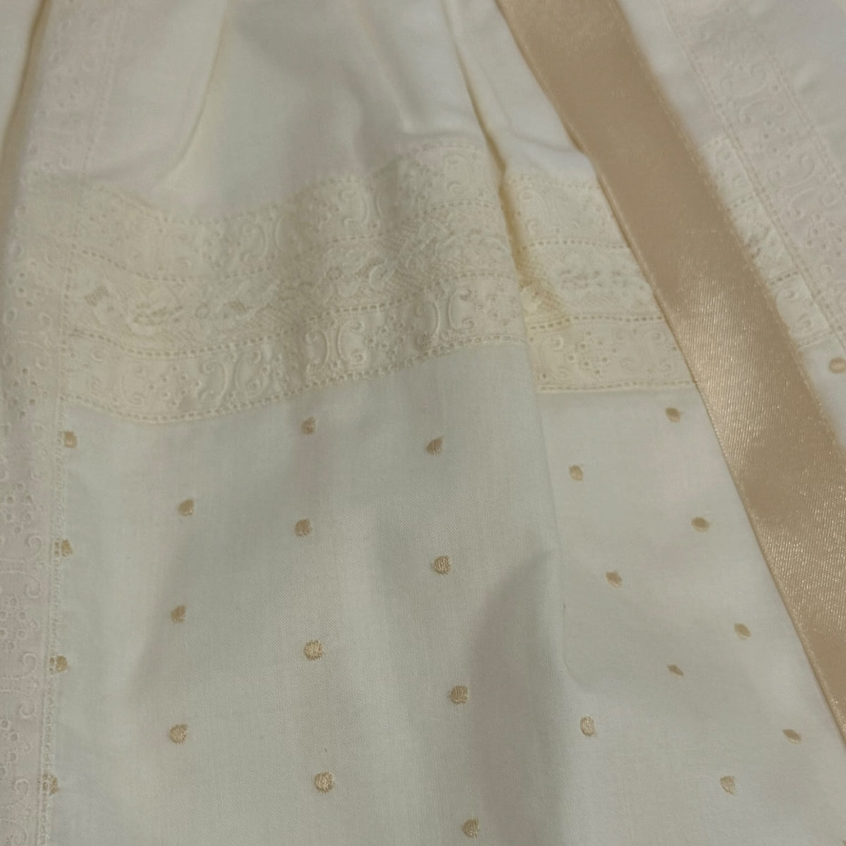 Close-up of beige satin ribbon and embroidered detailing on Gabriel Ivory Faldon Skirt