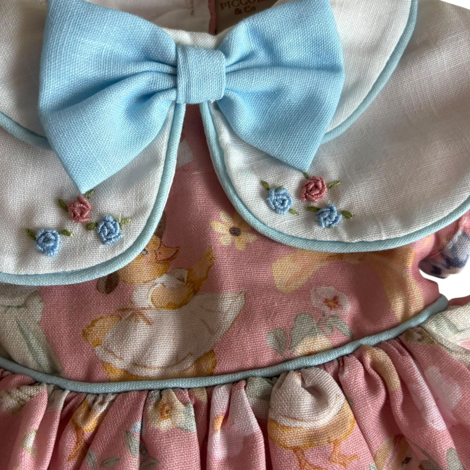 Close-up of blue collar, bow and embroidered detailing on Karla Garden Dress