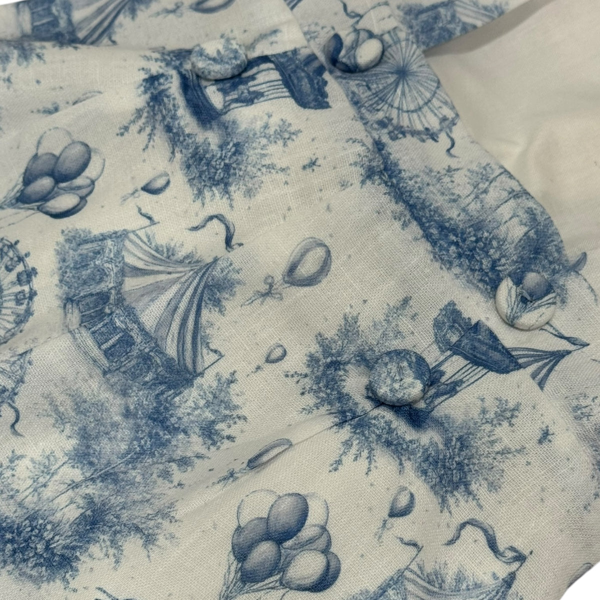 Close-up of blue circus toile print on Ollie Romper Set