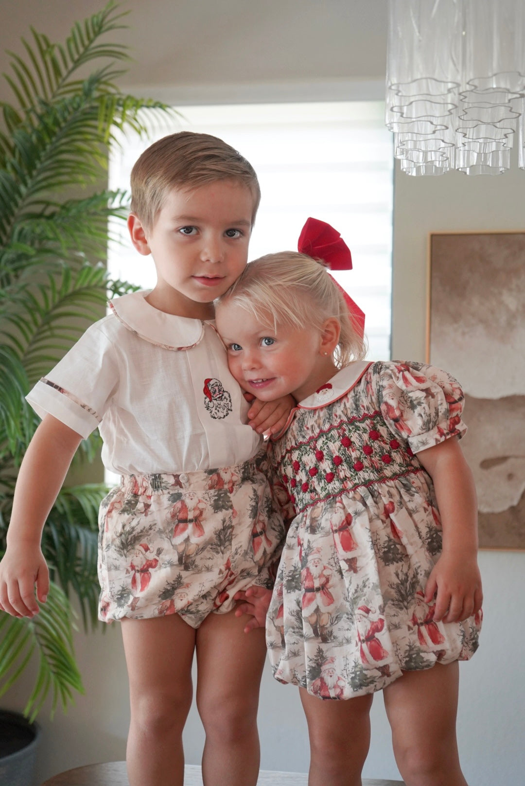 Children wearing coordinating Santa Claus Christmas outfits