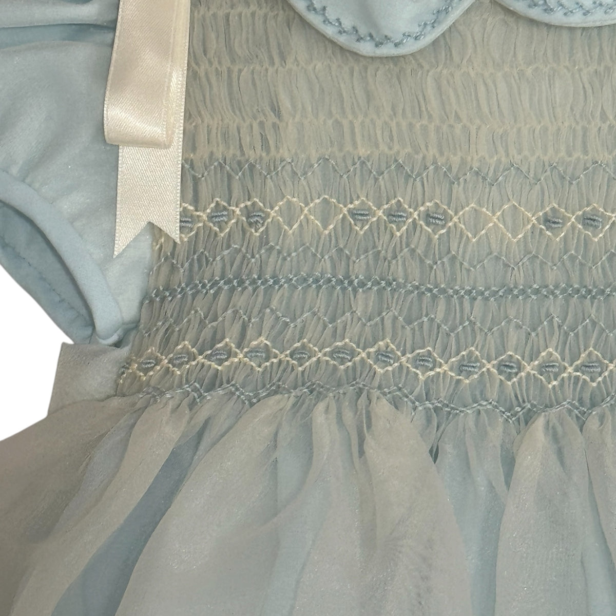 Close-up of light blue handsmocking across the chest on Agustin Romper