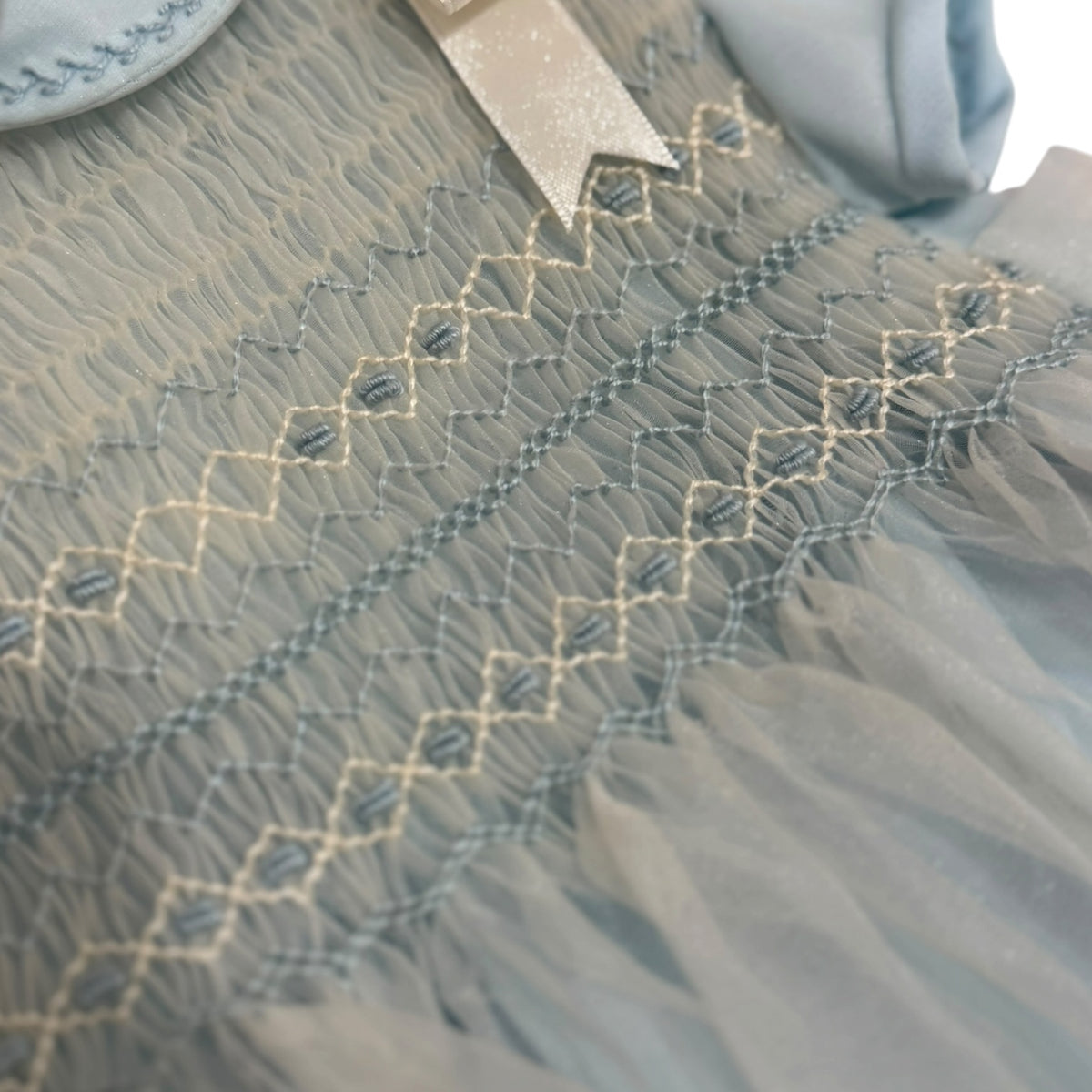 Close-up of intricate handsmocking on Agustin Light Blue Boy Romper