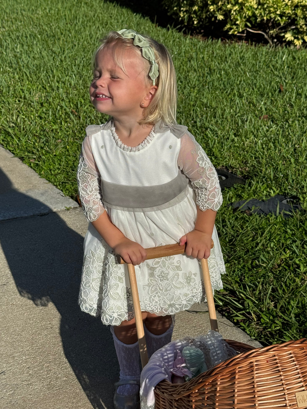 Girl smiling and wearing Tessa Velvet Bow Headband in spring moss with three satin and velvet bows