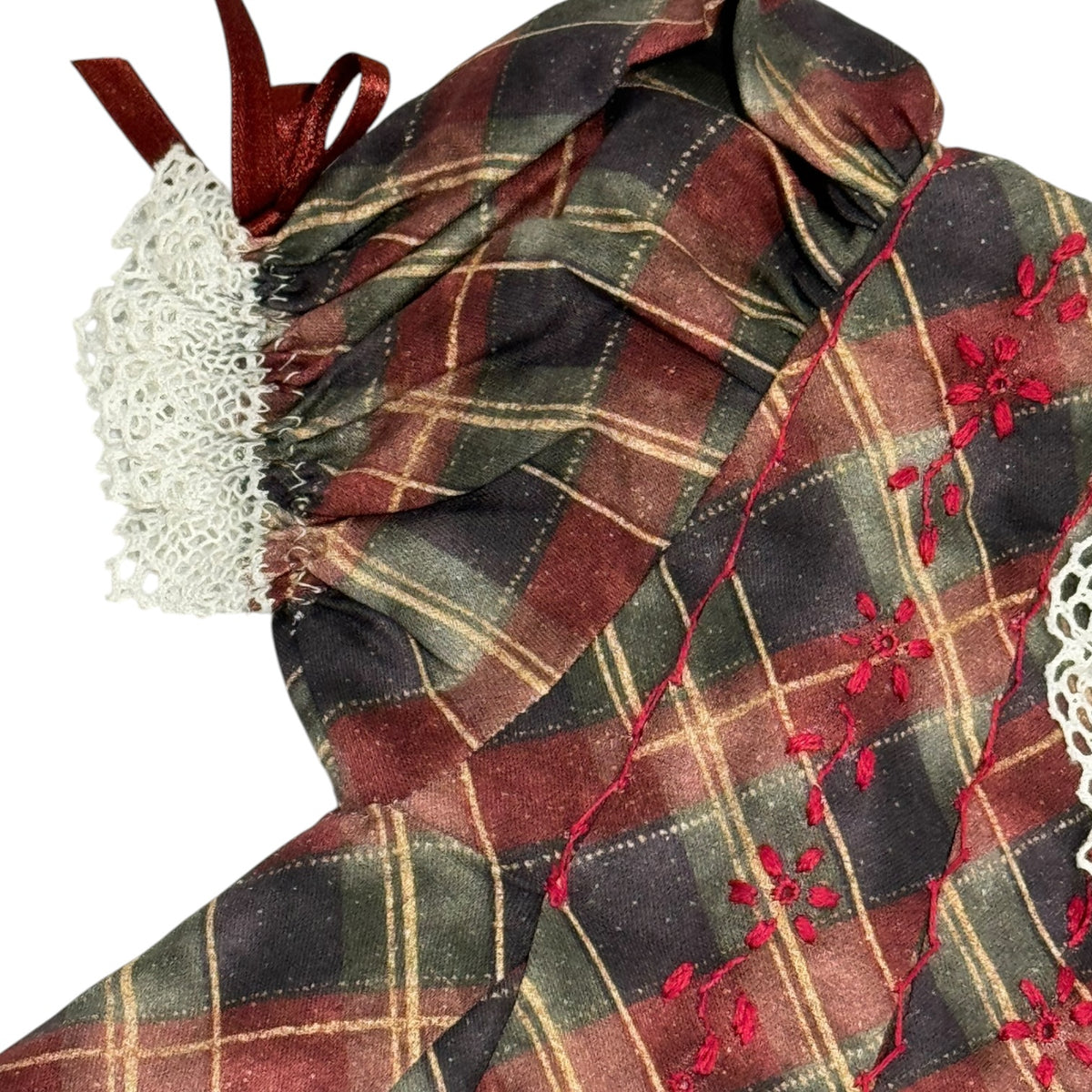 Close-up of tartan fabric, ivory lace trim and burgundy ribbon bow on Tartan Luxe Dress