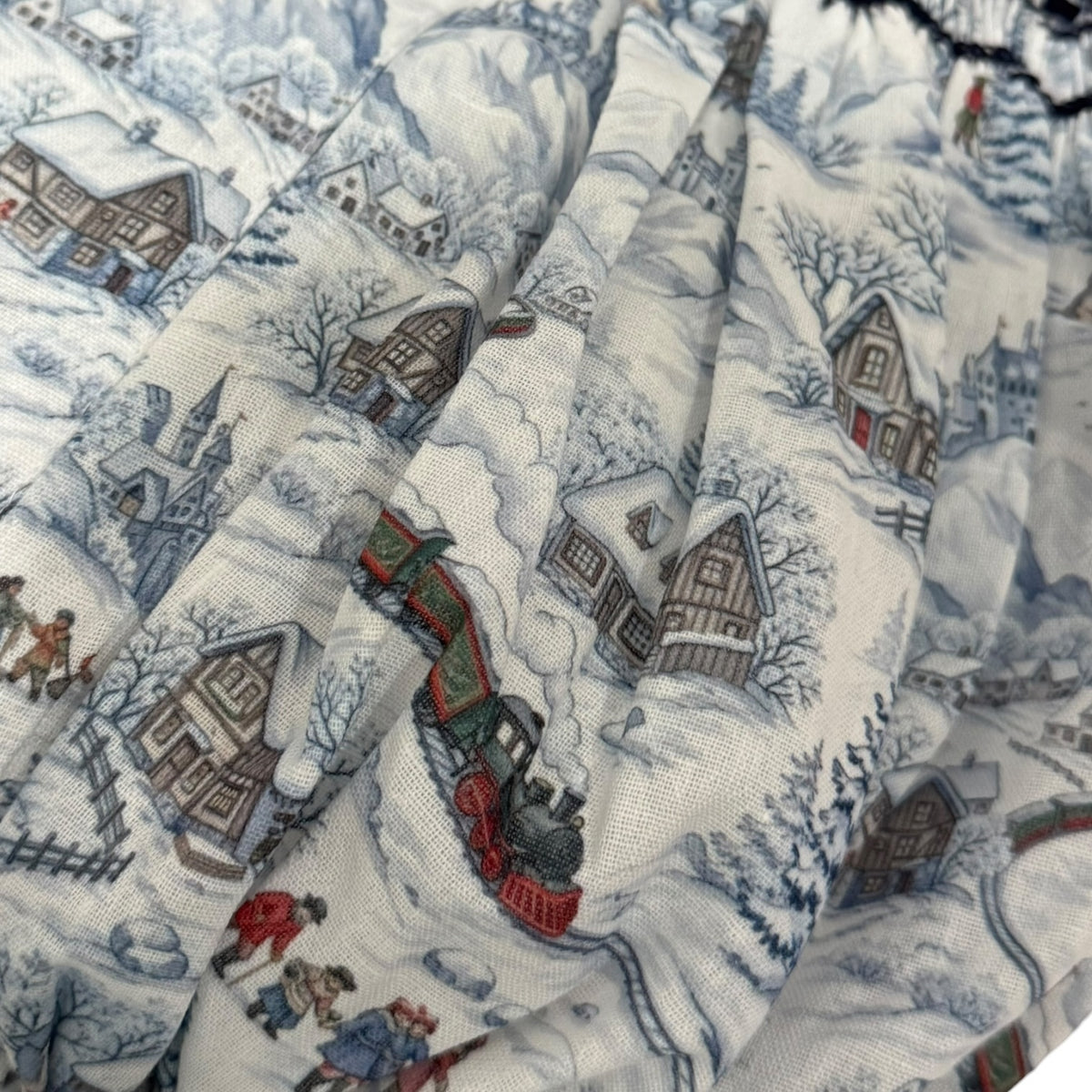 Close-up of snowy train toile print on The Polar Express Christmas romper