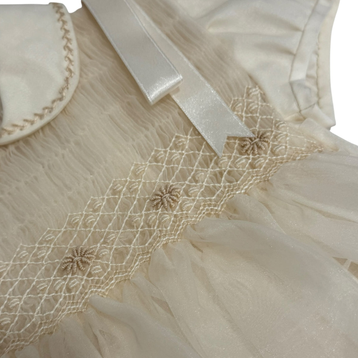 Close-up of ivory handsmocking and collar detailing on Lionel Romper