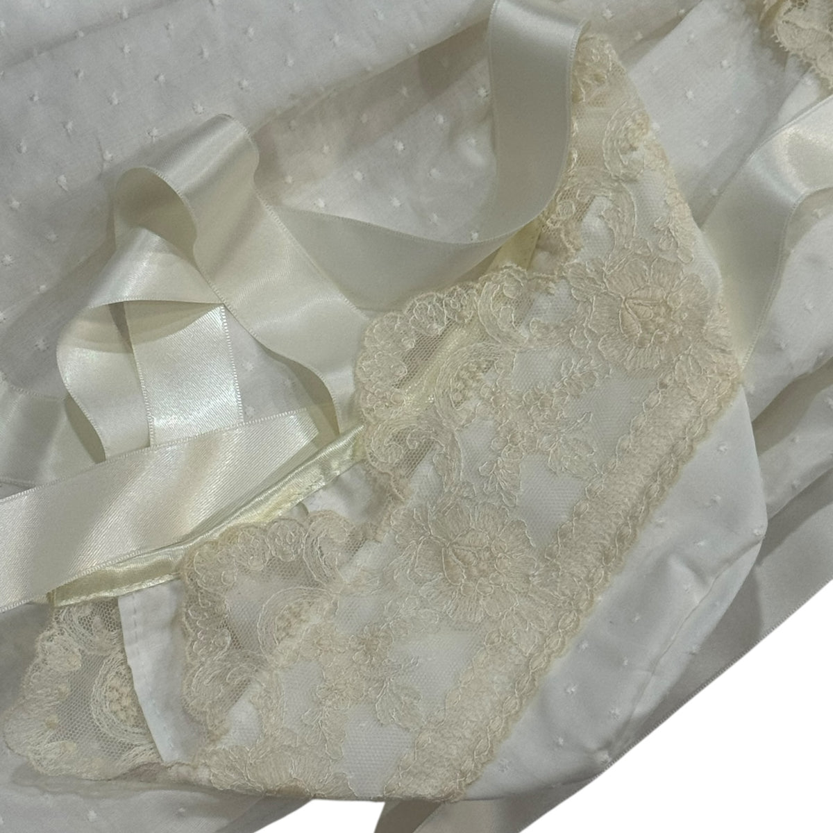 Close-up of ivory ribbon and Swiss dot fabric on Andrea Half-Knitted Gown