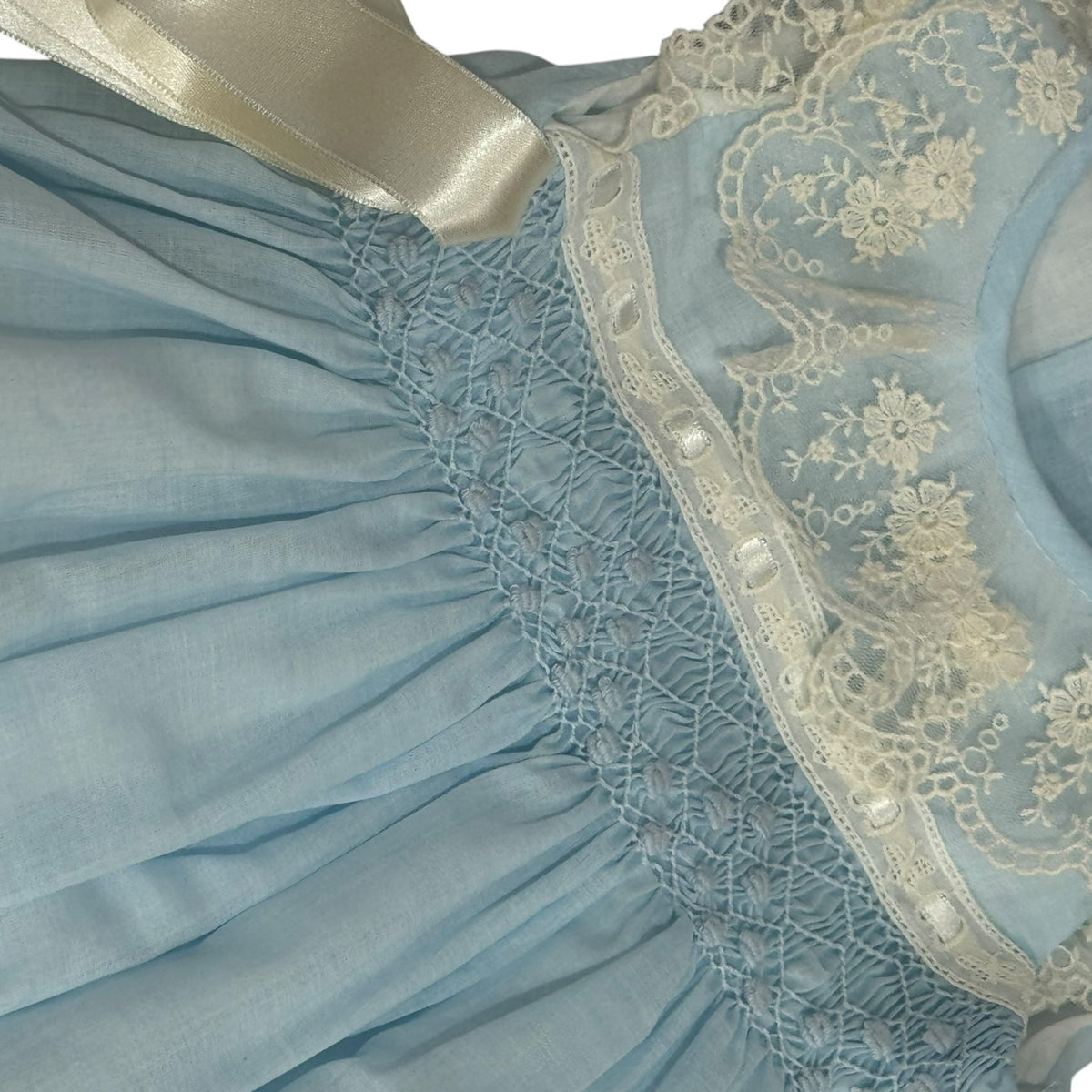 Close-up of delicate handsmocking on Helena Heirloom Light Blue Romper