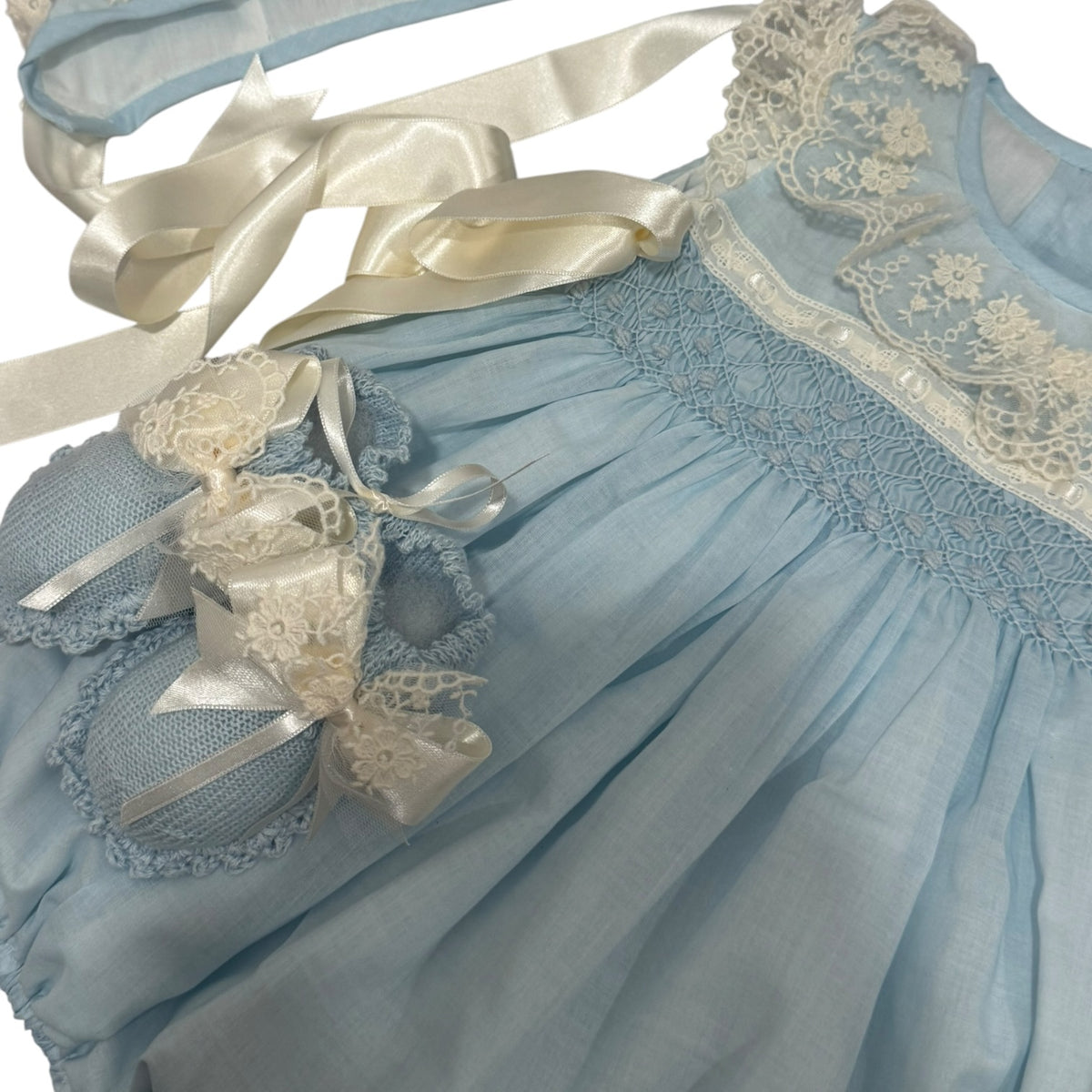 Close-up of gathered light blue fabric and handcrafted detailing on Helena Heirloom Romper