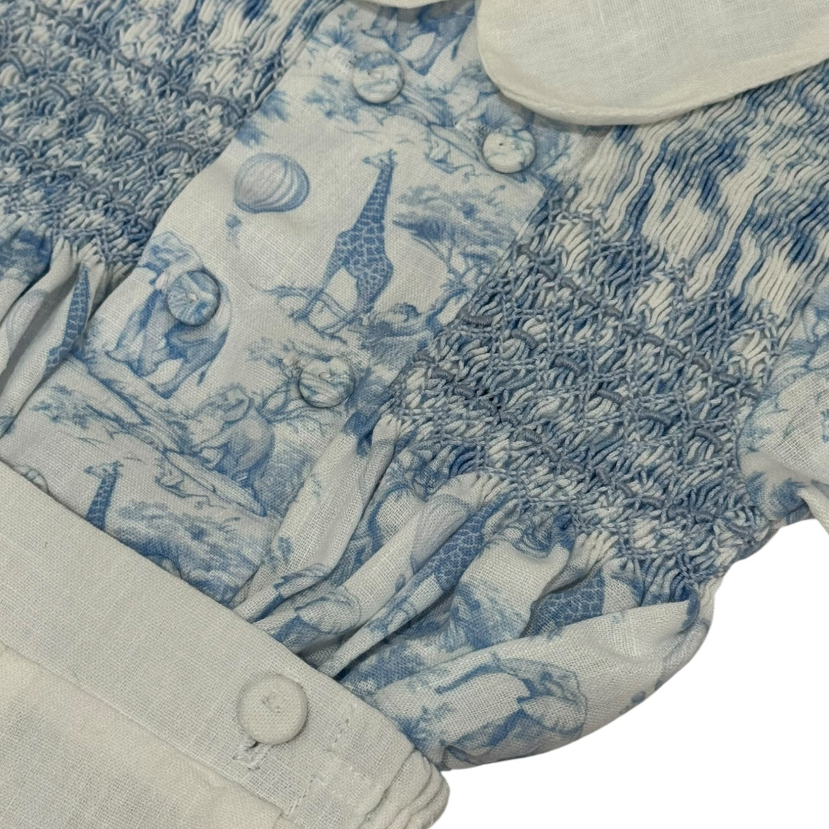 Close-up of blue safari toile print and handsmocking on Safari Blue Boy Set