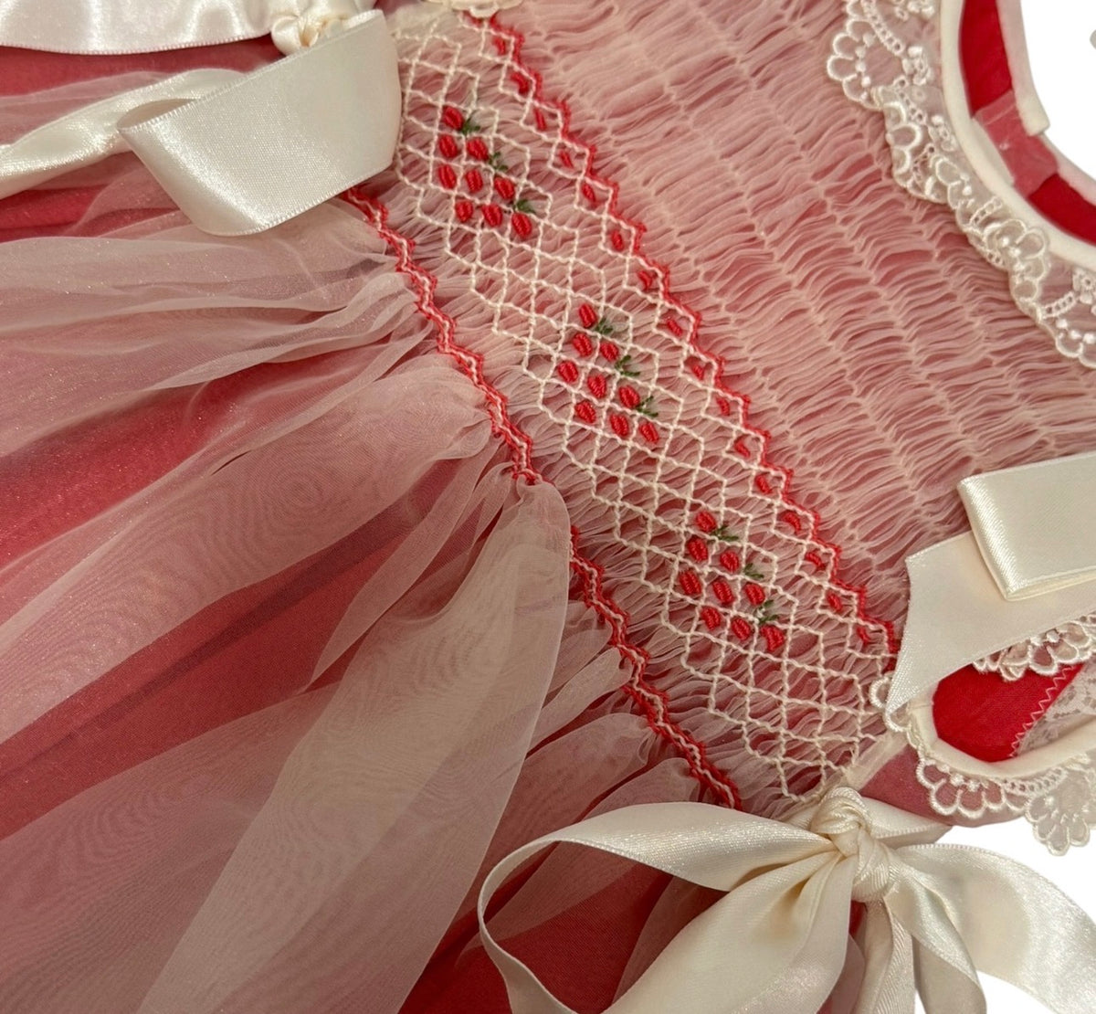 Close-up of ribbon bow and handsmocked bodice on Morgan Cranberry Dress