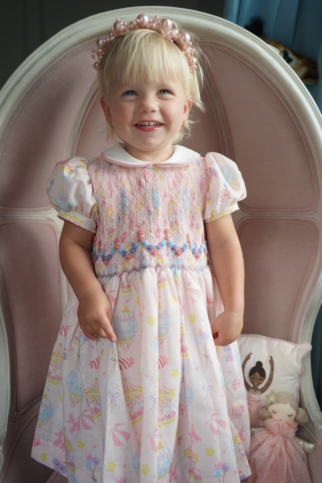 Girl wearing pastel Carnival Carousel Handsmocked Dress
