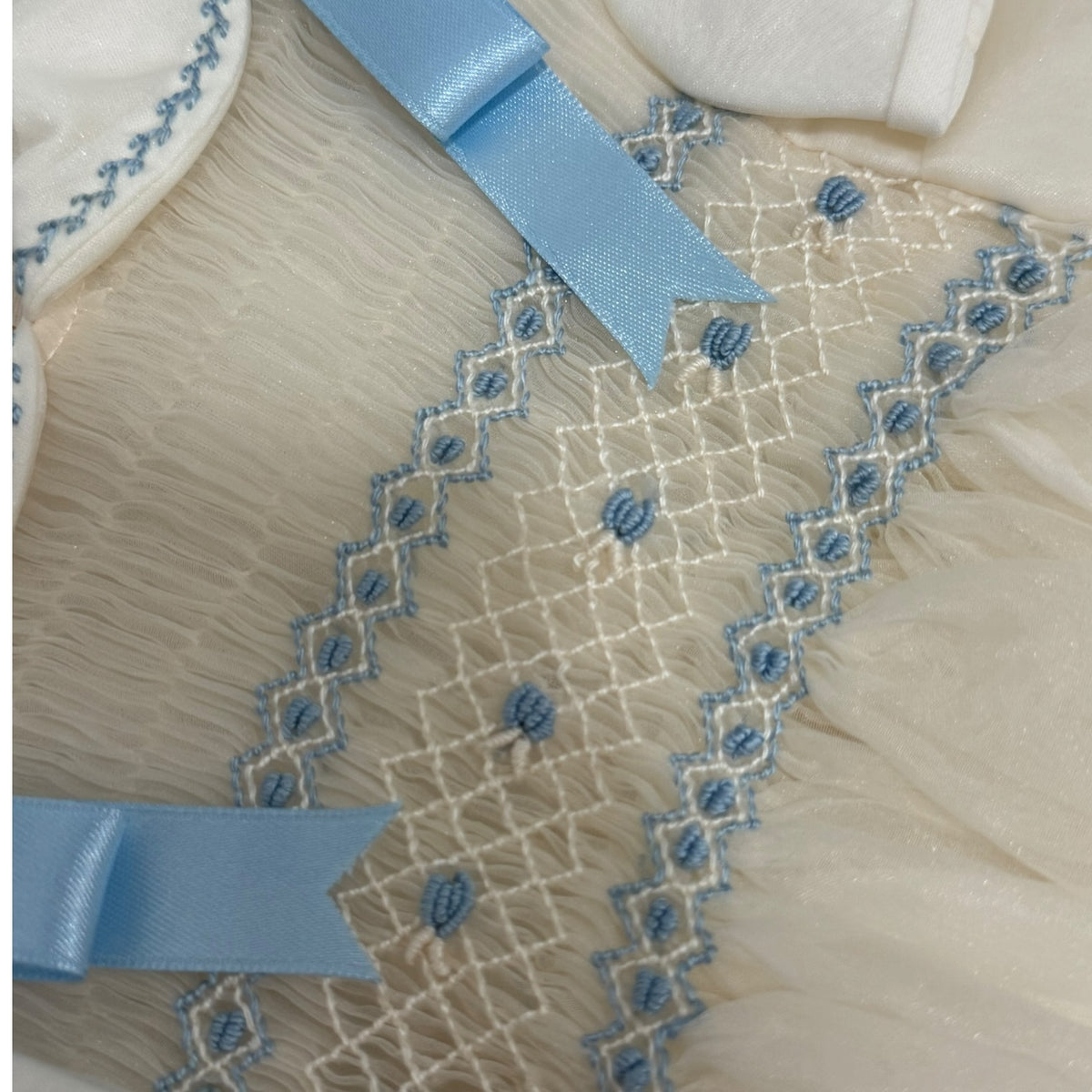 Close-up of light blue trim and handsmocking on Humbert Boy Romper