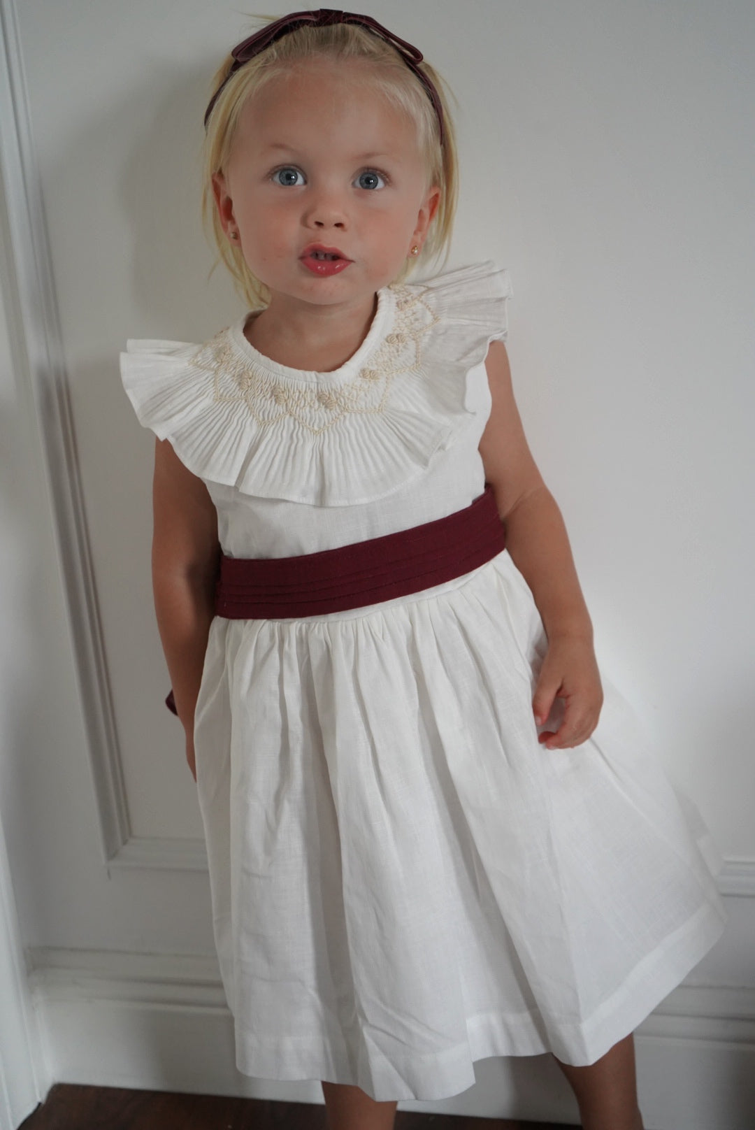 Girl wearing TPWC Flower Girl Dress with burgundy accents