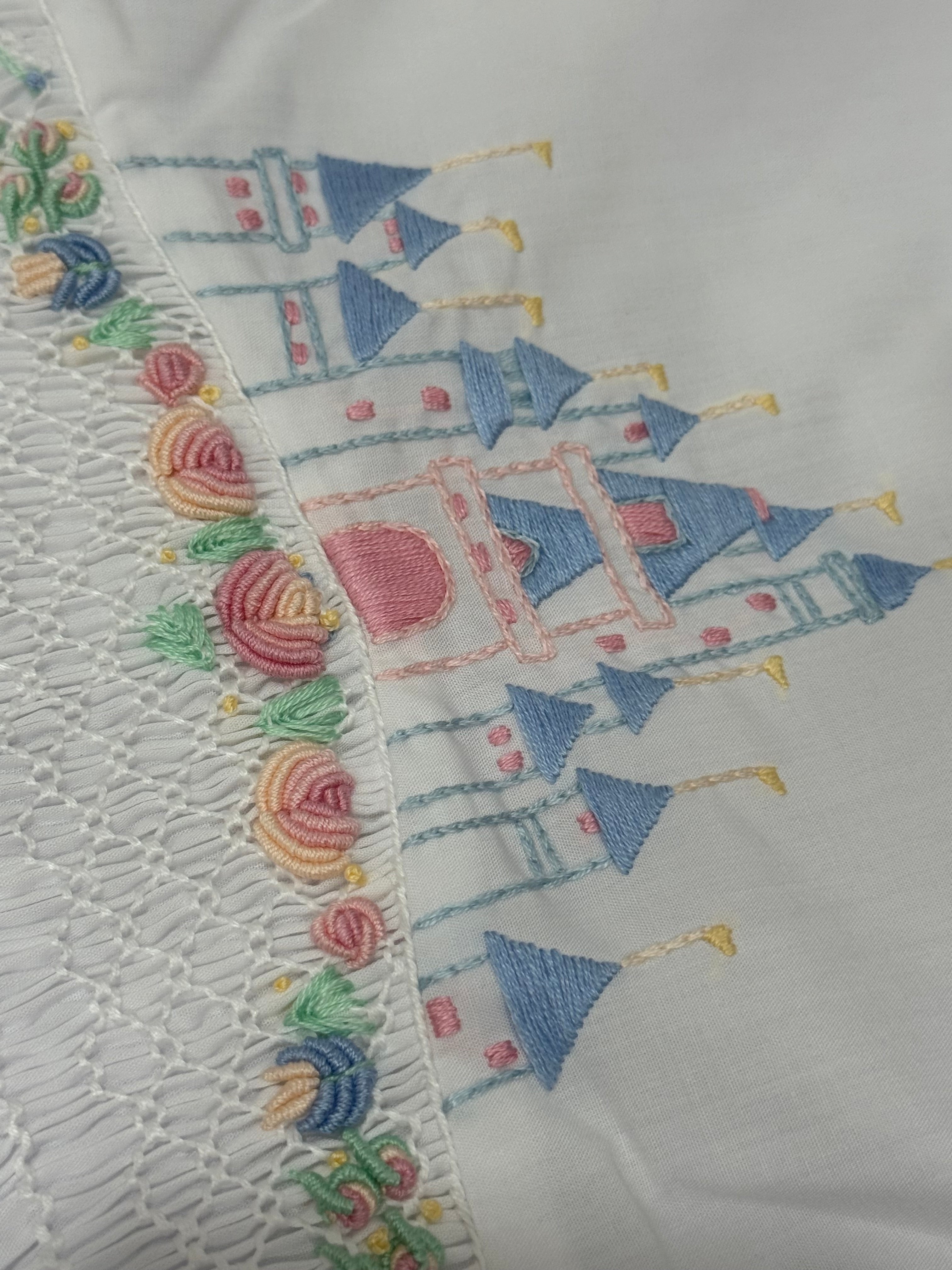 Close-up of colorful handsmocking and hand-embroidered detailing on Once Upon a Time White outfit