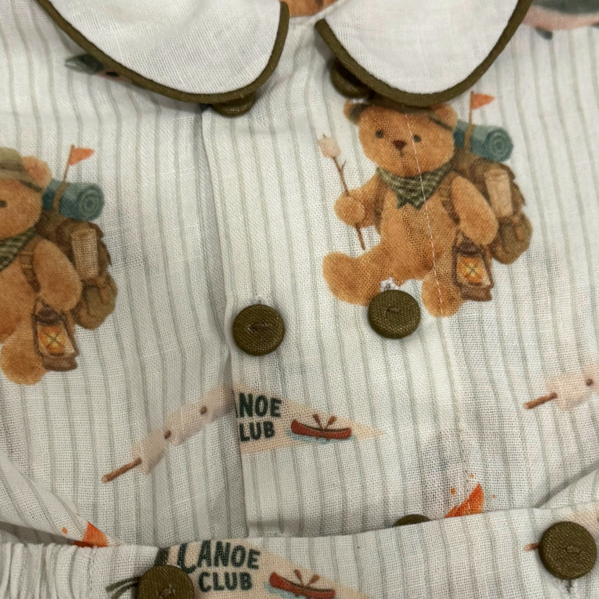 Close-up of double button detailing on camping bear shirt