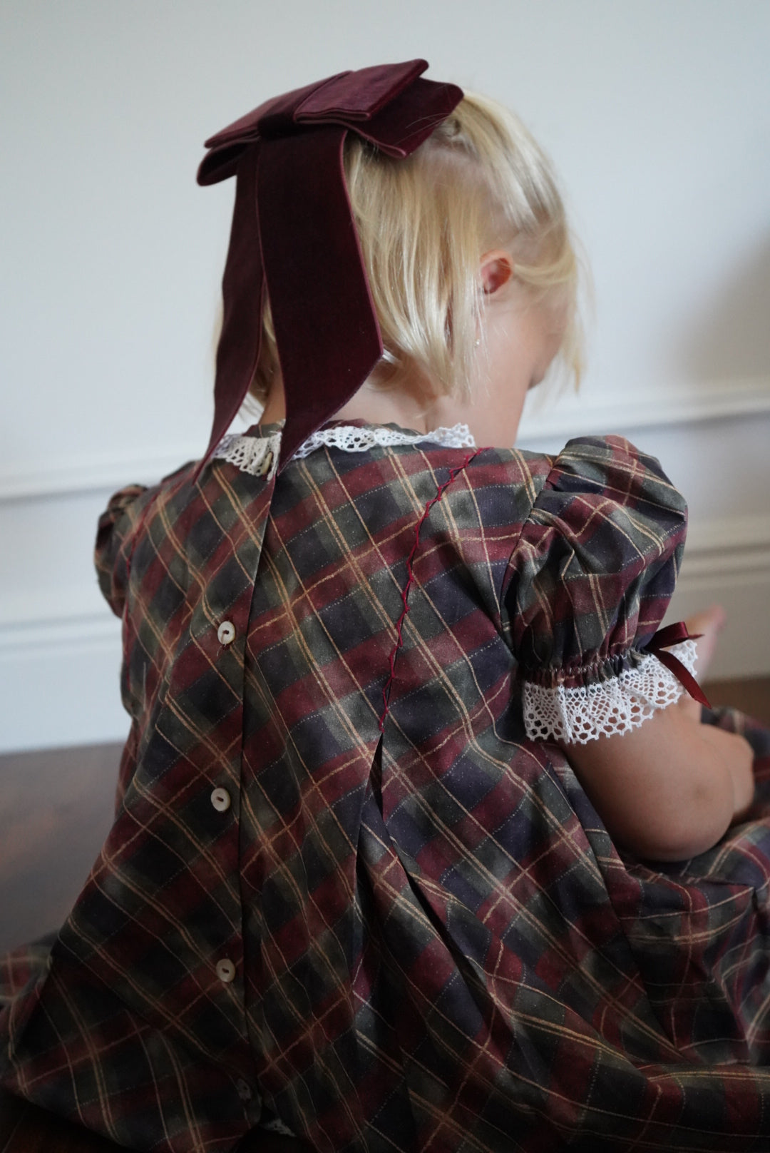 Back view of Tartan Luxe Handembroidered Dress with burgundy ribbon detail
