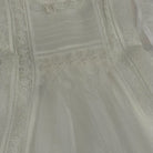 Close-up of white lace and handsmocked detailing on Addison Luxe Dress