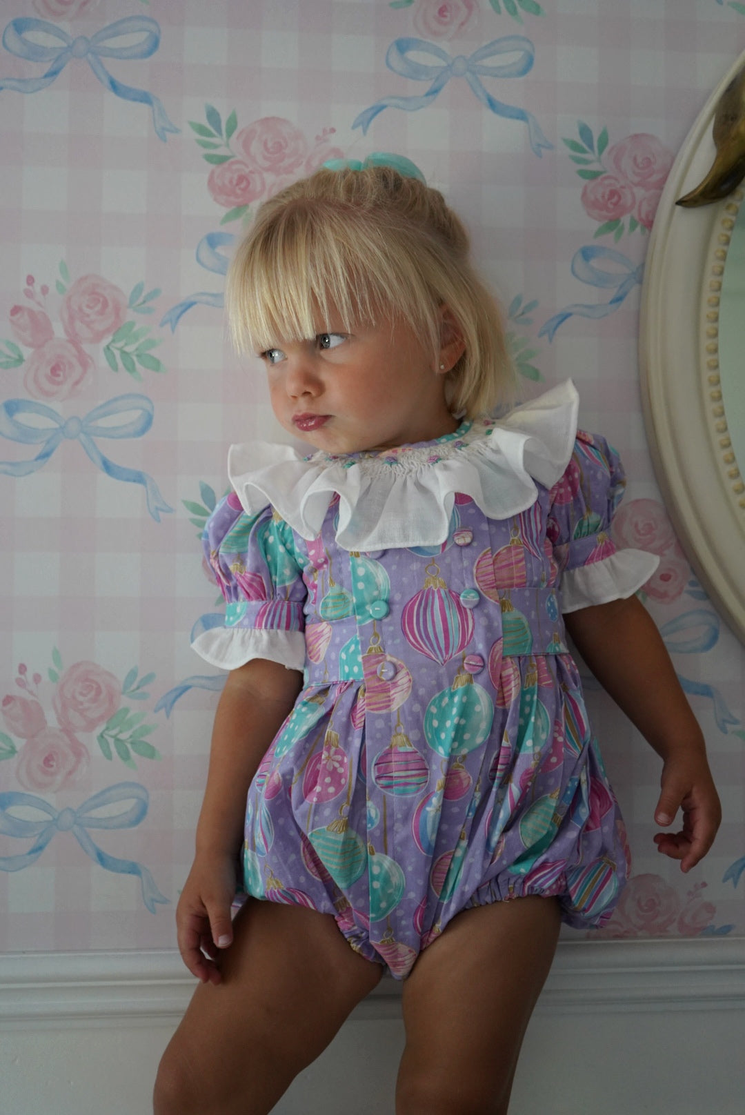 Side view of girl wearing Gigi Ornaments Pastels Handsmocked Romper