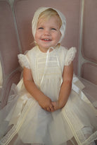 Girl wearing Regina Luxe Ivory Handsmocked Dress