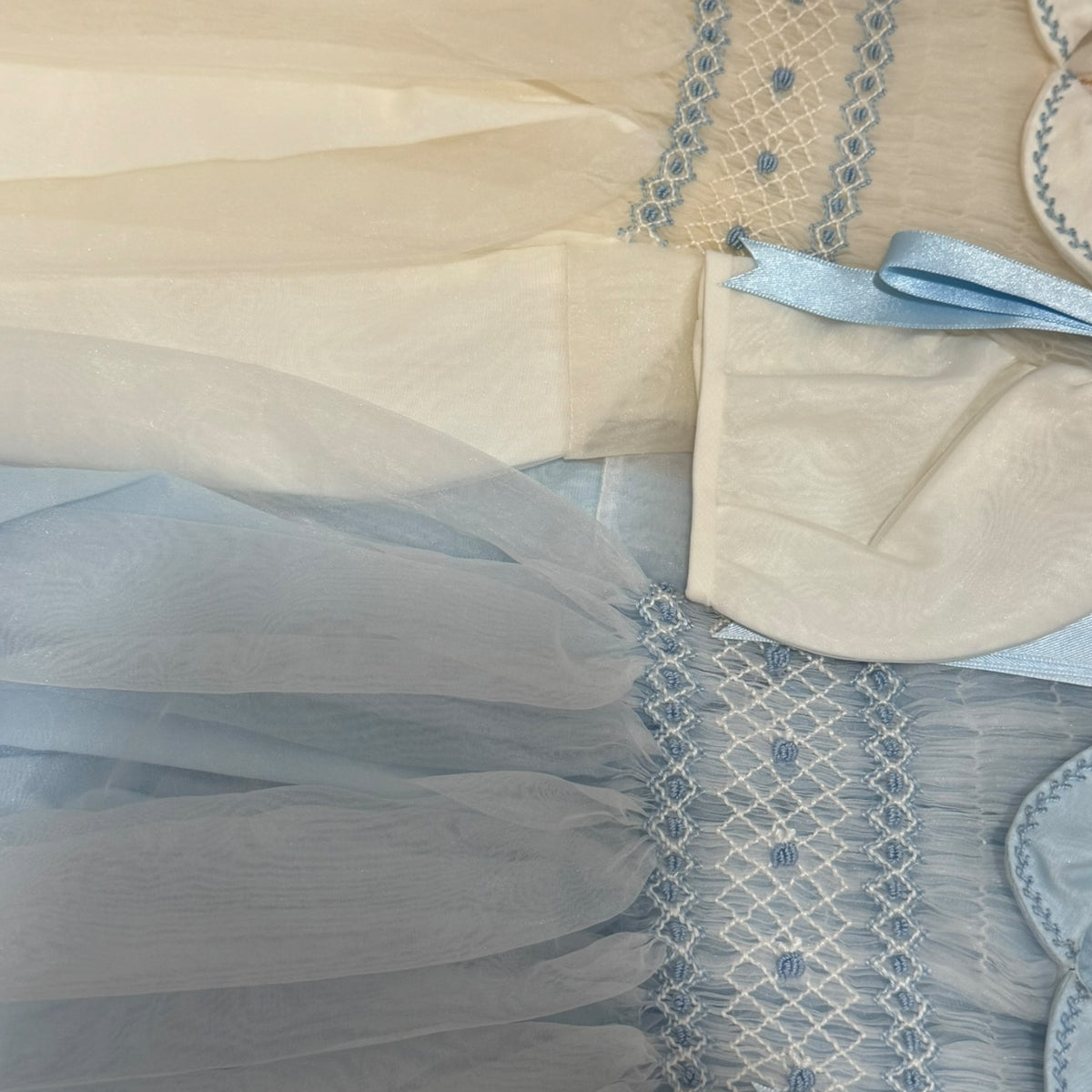 Close-up of ivory and light blue fabric detailing on Humbert Romper