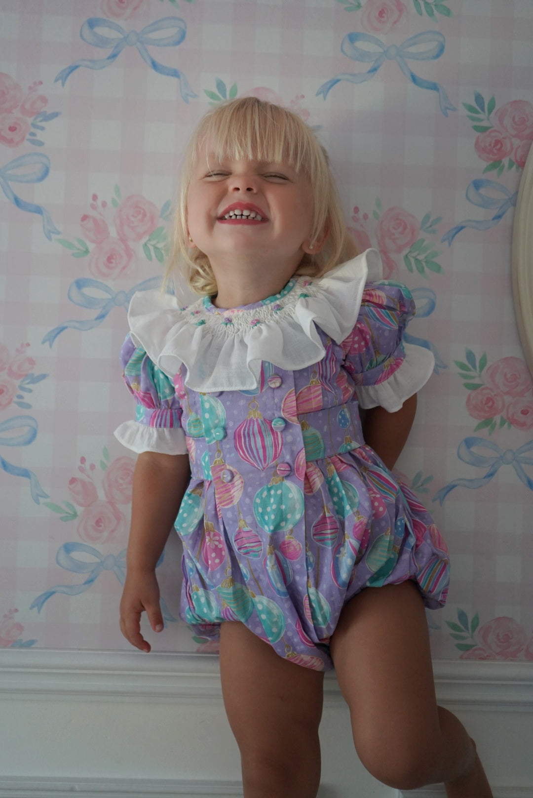 Girl standing in Gigi Ornaments Pastels Christmas romper