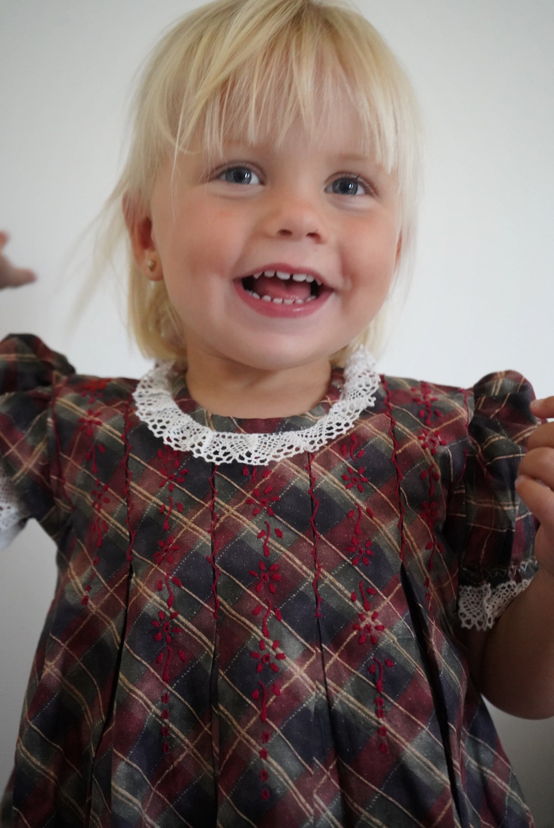 Girl smiling in Tartan Luxe Handembroidered Dress
