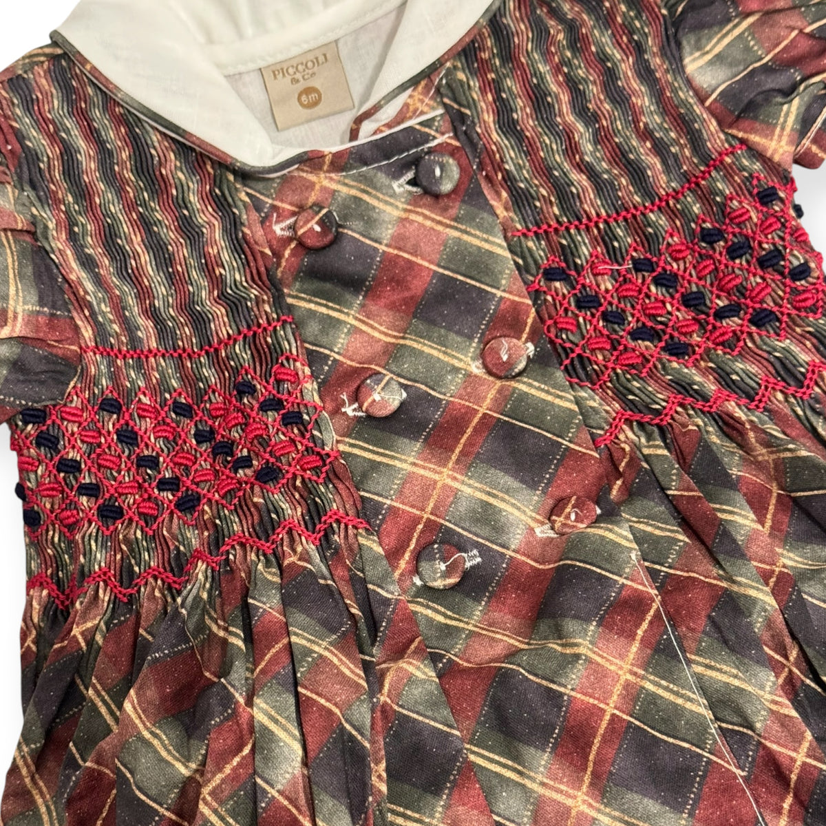 Close-up of handsmocked detailing and tartan fabric on Tartan Luxe Boy Christmas Romper